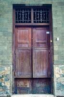 an old ancient wooden door on a medieval house in the old city of surabaya photo