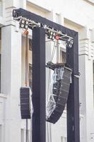 a pair of rigging, lighting, and line array speakers at a concert or large open-air performance photo