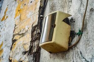 an old electric meter box attached to the wall of an old building photo
