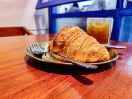 a plate of croissant bread served on a wooden table in a luxury cafe or restaurant photo
