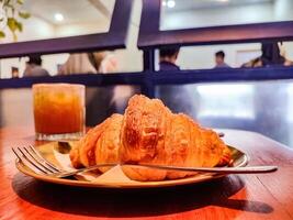 a plate of croissant bread served on a wooden table in a luxury cafe or restaurant photo