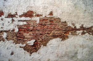 white walls that look like red bricks are cracked and corroded like an abstract art painting photo