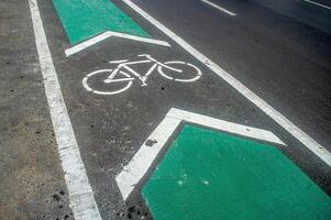 a bicycle way or bike lane on the side of an asphalt road in the city of Surabaya photo