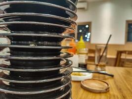 pile of plates of leftover sushi food in a Japanese restaurant with an all you can eat or buffet concept and Kaitenzushi or moving conveyor sushi. photo