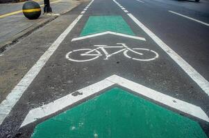 a bicycle way or bike lane on the side of an asphalt road in the city of Surabaya photo