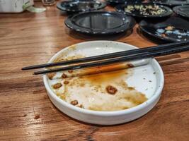many plates of leftover sushi at a Japanese restaurant with a pair of chopsticks on the plate. hygiene and health content. photo
