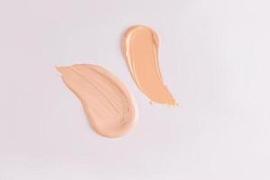Two beautiful strokes of liquid foundation powder on a white background. Layout for design, texture advertising, product. Near view. top view. photo