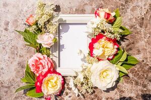 Floral frame for your congratulations with an empty space for text. White photo frame with fresh flowers. romantic composition. holiday. postcard