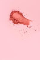 A chic sample texture of a loose blush in a classic tone on a pink background. A copy space. The top vertical view. Layout, texture sample. photo