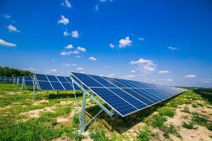 solar paneles en el verde campo en soleado clima. poder estación. azul solar paneles solar granja. foto