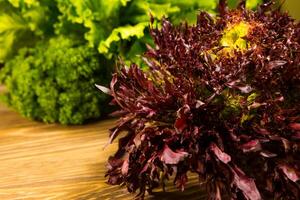 Leaves of lettuce and basil on a wooden background. Seasoning for the kitchen. photo