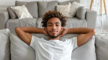 Relaxed Young Man Resting on Sofa in Modern Living Room, Casual Home Interior with Neutral Colors, Comfortable and Cozy Atmosphere, Daily Life Domestic Scene photo