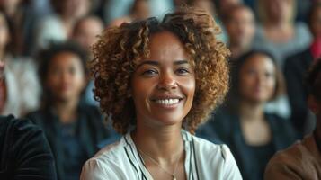 Smiling Woman In An Audience At Conference, Happy Female With Curly Hair In Professional Environment, Group Of People Networking, Business Event, Close-Up Portrait In Focus With Blurred Background photo