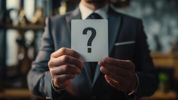 Businessman Holding a Blank Card with Question Mark in a Professional Office Setting photo