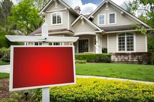 Empty Board Sign for Text. House for Sale with Red Blank Real Estate Sign in Front Yard, White Fence, Green Lawn, Spring Trees, and Sunny Sky photo