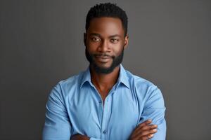 Confident Man in Blue Shirt Against Grey Background - Studio Portrait with Folded Arms, Casual and Professional Appearance photo