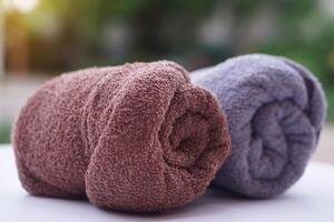 Rolled up towels. Outdoor background. Concept, clothes in daily life using. Towel for bathing, showering or spa massage. photo