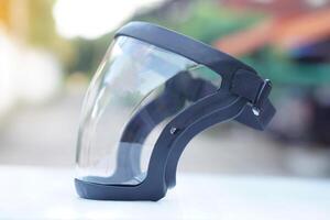 Protective safety face shield, Clear glass with black edge. Concept, tool, equipment use for wearing with face to protect from dust, germ spreading or others into face. Work Secured helmet shield. photo