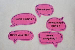 Pink paper speech bubbles cards with texts to ask questions about How are you Concept, Handmade English language teaching aid. English for communication in daily life. photo