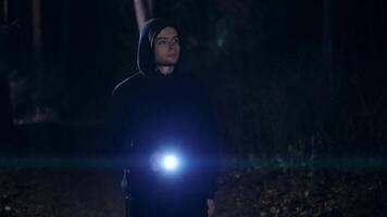A young man with a lantern in his hand walks through the night forest. It is dangerous to walk alone in the dark, in deserted places. video