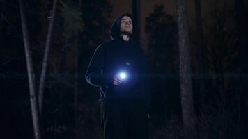 A young man with a lantern in his hand walks through the night forest. It is dangerous to walk alone in the dark, in deserted places. video
