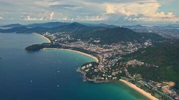 Tropical beach surrounded by mountains, water, and clouds in aerial view. View of the beaches of Kata and Karon, Phuket islands. video