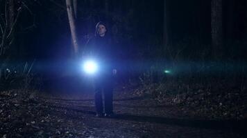 A young man with a lantern in his hand walks through the night forest. It is dangerous to walk alone in the dark, in deserted places. video