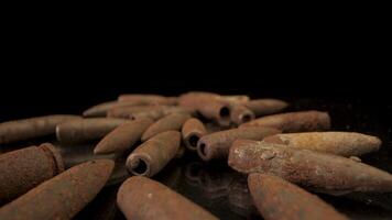 Close-up of old rusty bullets. Bullets lie chaotically on a black surface. video