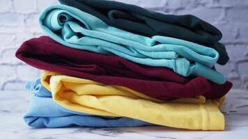 Colorful stack of clothes against brick wall, creating vibrant and organized look in modern setting video