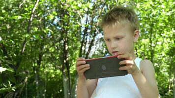 young boy engrossed in a game on a mobile device becomes alienated from his surroundings, illustrating the potential problems of early gadget addiction video