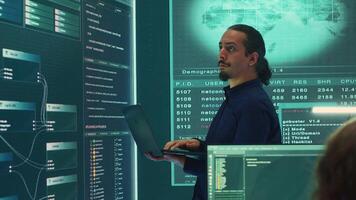 Governmental hacker expert working on securing digital information, analyzes intelligence on big screen. Specialist works to prevent cyber threats with advanced technology, cyberterrorism. Camera A. video