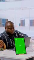 Vertical Businessman discussing with the real estate agents next to chroma key on tablet, meeting to negotiate leasing contract terms before looking at blueprints for an office relocation. Camera A. video