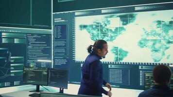 Cyber defense team working in a governmental security operations center. Experts ensuring cybercrime prevention and data breach protection, examining information on a big screen. Camera B. video