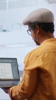 Vertical Business team evaluating architectural blueprints layout for high class office space, considering a property investment deal. Professionals negotiating with the realtor for rental agreement. Camera B. video