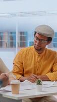 Vertical Clients and realtor on an office tour evaluating modern workspace design and discussing investment strategies and leasing options. Reviewing blueprints and planning office relocation. Camera B. video