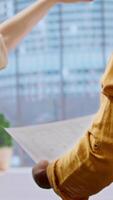 Vertical Realtor and clients sharing workspace design vision on office tour, evaluating modern property layout and blueprints before moving to high class urban setting. Leasing contract negotiation. Camera A. video
