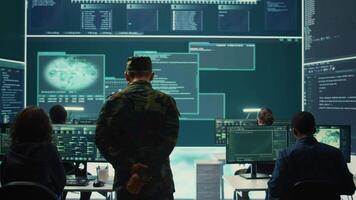 Military hackers working on cyber security in a high tech government center. Focusing on network protection, encryption and preventing cyber attacks to safeguard state secrets. Camera B. video