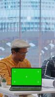 Vertical Contractors showing the office space plans next to laptop with chroma key, presenting the architectural blueprints to client. Business person looking to invest in property for development. Camera B. video