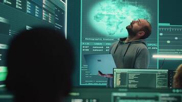 informatica difesa esperto l'esame dati su un' grande schermo nel governativo agenzia, messa a fuoco su informatica operazioni e digitale sicurezza. pirata assicura protezione contro criminale informatico attività. telecamera un. video