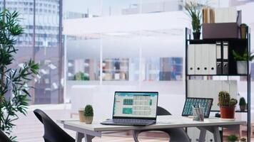 Empty financial department with stock portfolio on laptops and paperwork files filled with marketing charts. Panning shot of forex exchange indices on notebook device screen video