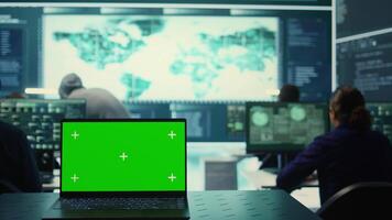 Laptop showing green screen in a governmental high tech office, cyber security team working on network security and data protection. Focusing on ransomware and other cyber threats. Camera B. video
