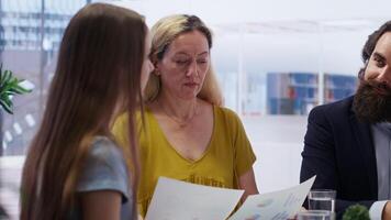 finansiell rådgivare diskuterar med klienter handla om betydelse av budgetering i inkomst planera och förvaltning bearbeta. familj utforska bäst praxis för byggnad pengar sparande vanor, kamera b video