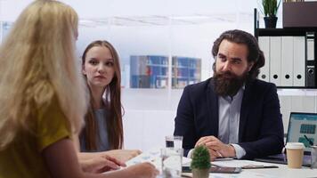 Financial advisor developing and presenting financial strategies and plans to family members. Consultant in workspace assisting clients with investment portfolio management, camera B video