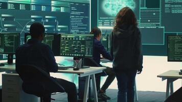 Governmental hackers team securing computer systems from cyber threats, working together in agency control room. Emphasizing encryption, online security and espionage against cyber attacks. Camera A. video