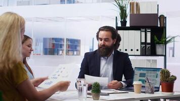 Financial adviser providing clients with informative leaflets on retirement planning, tax issues and wealth management. Agent in office assisting clients in setting up investment accounts, camera B video