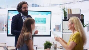 Financial advisor discussing with clients, recommending suitable financial products such as mutual funds. Agent teaching parent and daughter how to invest, offering statistical graphs, camera B video