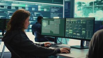 Governmental hackers team working on digital security and cyber defense measures, using pc and big screen. Experts focusing on cyber operations, network security and server protection. Camera B. video