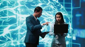 Coworkers using AI neural networks modeled after human brain, brainstorming ways to solve complex problems. IT department staff members using deep learning to look at data and complete tasks, camera A video