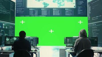 Cyber security experts working with mockup layout on a big screen, using encryption and IT security in a governmental agency. Focusing on cyber operations to hack rival states systems. Camera B. video