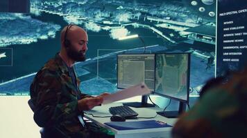 Military operator transmitting gps coordinates of hostile ships to national guard, providing real time data from surveillance CCTV system. Army officer works in power base control center. Camera B. video